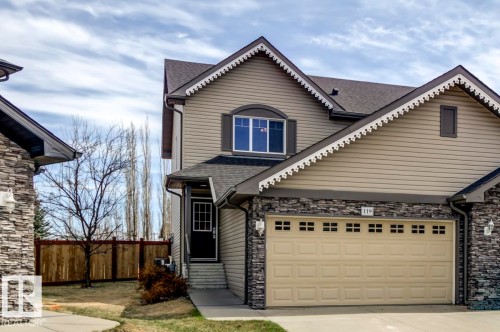 Two-story residence featuring light brown siding and stone veneer accents - 119 Rue Monique, Beaumont, AB - Outdoor