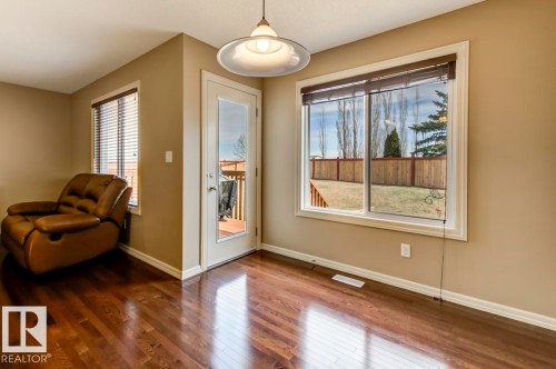 Spacious room featuring wood-finish flooring, neutral wall tones, and white trim - 119 Rue Monique, Beaumont, AB - Indoor Photo Showing Other Room