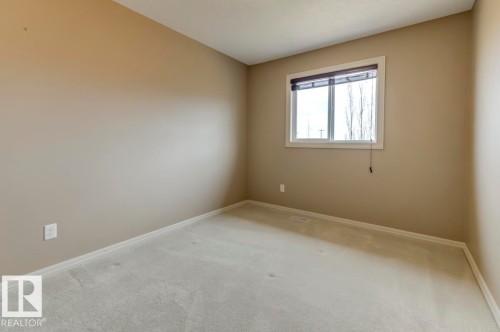 Neutral-toned interior with light-colored carpeting - 119 Rue Monique, Beaumont, AB - Indoor Photo Showing Other Room