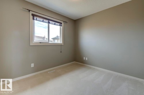 Neutral-toned walls complement plush carpeting - 119 Rue Monique, Beaumont, AB - Indoor Photo Showing Other Room