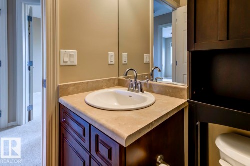 Bathroom vanity featuring a polished chrome faucet, an integrated sink, and a light-toned countertop - 119 Rue Monique, Beaumont, AB - Indoor Photo Showing Bathroom