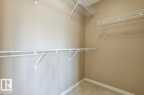 Spacious walk-in closet featuring wire shelving and hanging rods - 119 Rue Monique, Beaumont, AB - Indoor With Storage