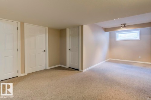 Carpeted interior space with neutral wall tones and white trim - 119 Rue Monique, Beaumont, AB - Indoor
