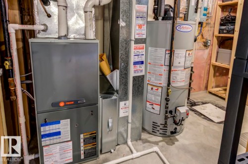 Utility area featuring a Trane HVAC system, Reliance water heater, and exposed ductwork - 119 Rue Monique, Beaumont, AB - Indoor Photo Showing Basement