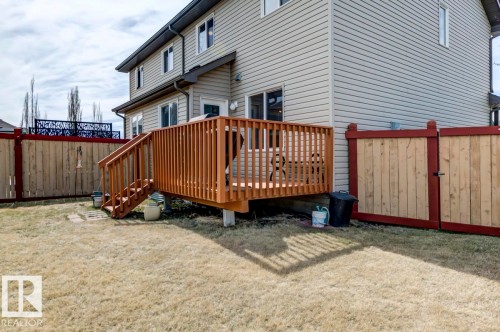 Rear exterior with light-toned horizontal siding - 119 Rue Monique, Beaumont, AB - Outdoor With Deck Patio Veranda With Exterior