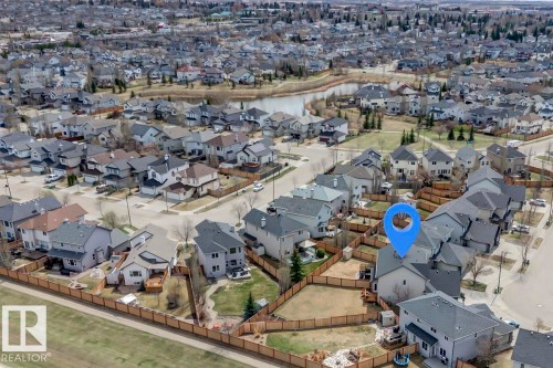 Aerial perspective showcasing a residential neighborhood with a prominent body of water - 119 Rue Monique, Beaumont, AB - Outdoor With View
