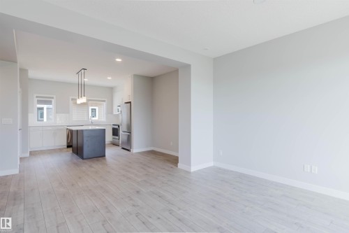 Open-concept living space with light wood-finish flooring - 3 11373 12 Avenue, Edmonton, AB - Indoor