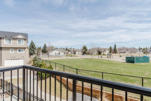 Exterior balcony with black metal railings overlooking a green lawn area - 3 11373 12 Avenue, Edmonton, AB - Outdoor With Balcony