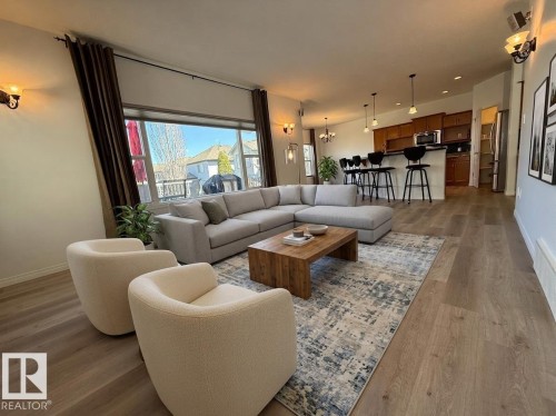 Spacious room featuring wood-finish flooring, a full-lite exterior door, and a large multi-pane window - 2335 Rutherford Way, Edmonton, AB - Indoor Photo Showing Other Room