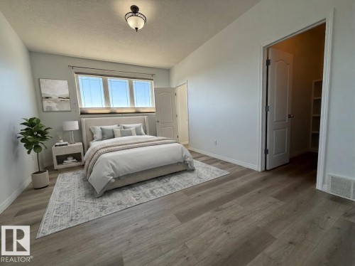 Spacious room featuring wood-finish flooring, white baseboards, and a window with blinds - 2335 Rutherford Way, Edmonton, AB - Indoor Photo Showing Other Room