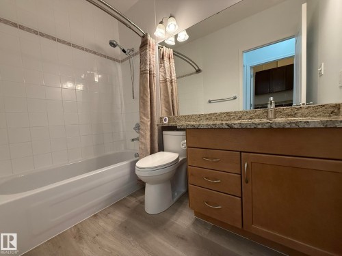 Bathroom featuring a full vanity with a granite-style countertop, wood-finish cabinetry, and a modern sink faucet - 2335 Rutherford Way, Edmonton, AB - Indoor Photo Showing Bathroom