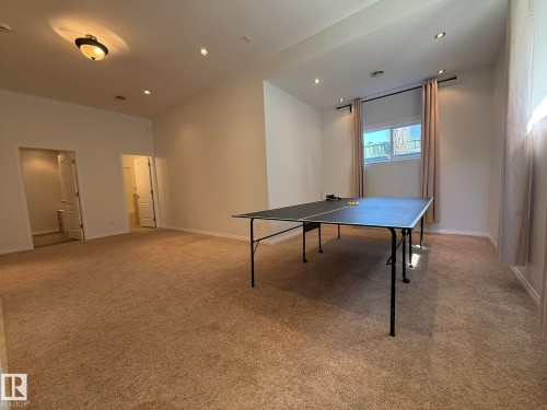 Spacious carpeted room featuring recessed lighting, a ceiling-mounted light fixture, multiple doorways, and a window with curtains - 2335 Rutherford Way, Edmonton, AB - Indoor Photo Showing Other Room