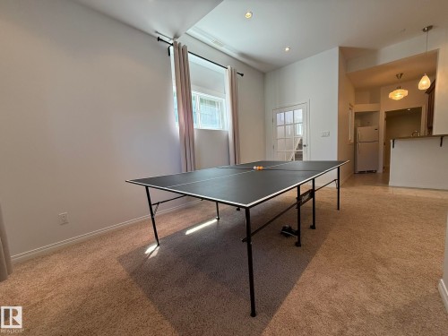 Carpeted room with a full-light French door, recessed lighting, and a window with curtain rod and drapes - 2335 Rutherford Way, Edmonton, AB - Indoor