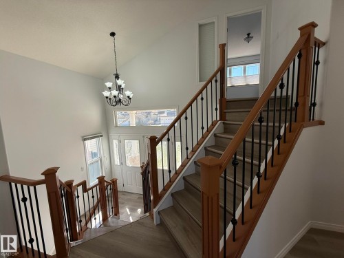 Grand entryway featuring a two-story ceiling, a wrought iron chandelier, and wood-finish flooring - 2335 Rutherford Way, Edmonton, AB - Indoor Photo Showing Other Room