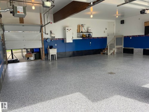 SUCH A GREAT SIZED 31x25 TRIPLE ATTACHED HEATED DRIVE-THRU GARAGE WITH THE NEW EPOXY FLOORING & A FLOOR DRAIN WITH HOT & COLD DEEP SOAKER SINK & RADIO/SOUND SYSTEM ALL INCLUDED! - 2335 Rutherford Way, Edmonton, AB - Indoor Photo Showing Garage