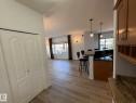 Open-concept living space featuring wood-finish flooring, a kitchen island with pendant lighting, and abundant natural light from broad windows - 2335 Rutherford Way, Edmonton, AB  - Indoor Photo Showing Other Room 