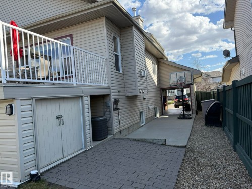 CLOSE UP LOOK AT THE BUILT-IN SHED UNDER THE DECK & THE A/C UNIT IS COVERED TOO! AND YOU CAN SEE THE DRIVE-THRU SINGLE GARAGE WITH A CONCRETE PAD TO PARK YOUR TOYS, SMALL BOAT OUT OF SITE! - 2335 Rutherford Way, Edmonton, AB - Outdoor With Exterior