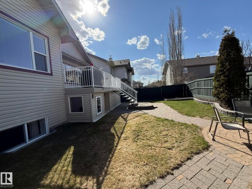 Rear exterior featuring a multi-level deck with white railings, a paver patio, a curved paver pathway, and a privacy fence - 2335 Rutherford Way, Edmonton, AB - Outdoor With Deck Patio Veranda With Exterior
