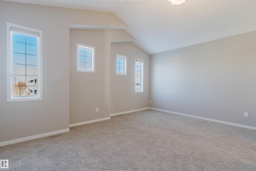 Spacious room featuring vaulted ceilings, light gray wall paint, and gray carpet flooring - 16627 18 Avenue, Edmonton, AB - Indoor Photo Showing Other Room