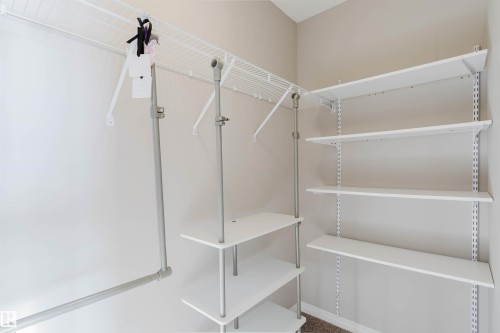 Walk-in closet with integrated wire shelving, adjustable flat shelving, and a hanging clothes rod - 16627 18 Avenue, Edmonton, AB - Indoor With Storage