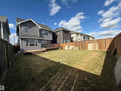 Rear exterior featuring gray horizontal siding, a multi-level wood deck, and a fenced yard - 16627 18 Avenue, Edmonton, AB - Outdoor