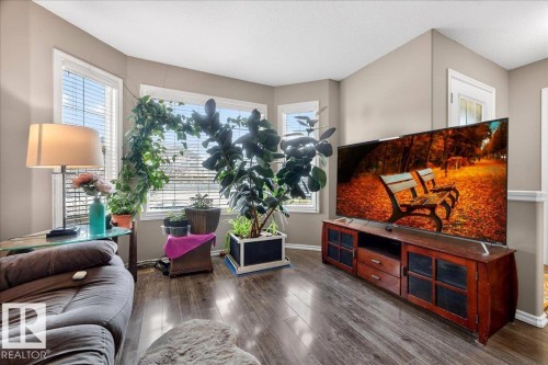 Bay window with white trim, wood-finish flooring, neutral wall paint, and a built-in media console - 18080 89 Street, Edmonton, AB - Indoor