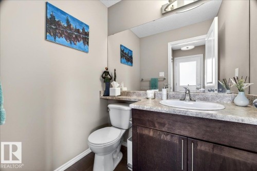 Powder room featuring a single vanity with an integrated sink, a dark wood-finish cabinet, and a light-toned countertop - 18080 89 Street, Edmonton, AB - Indoor Photo Showing Bathroom