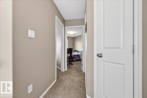 Hallway featuring neutral wall paint, white trim, and textured carpet flooring - 18080 89 Street, Edmonton, AB - Indoor Photo Showing Other Room