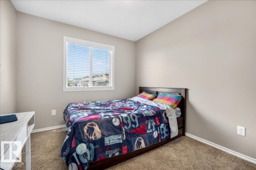 Neutral-toned bedroom featuring a window with horizontal blinds, light beige walls, and brown carpet flooring - 18080 89 Street, Edmonton, AB - Indoor Photo Showing Bedroom