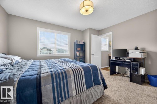 Bedroom featuring neutral wall paint, white trim, and a large window with horizontal blinds - 18080 89 Street, Edmonton, AB - Indoor Photo Showing Bedroom
