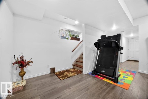 Bright lower level space featuring recessed lighting, a window, wood-finish flooring, and a white paneled door - 18080 89 Street, Edmonton, AB - Indoor