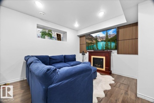 Entertainment space featuring wood-finish flooring, recessed lighting, and a built-in fireplace with a traditional mantel - 18080 89 Street, Edmonton, AB - Indoor Photo Showing Other Room With Fireplace