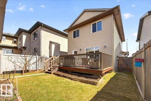 Rear elevation featuring tan siding, a ground-level green lawn, and a wood deck with stairs - 18080 89 Street, Edmonton, AB - Outdoor With Deck Patio Veranda With Exterior