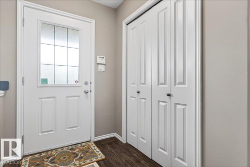 Entryway featuring a white paneled door with a multi-pane frosted glass insert, wood-finish flooring, and neutral wall paint - 18080 89 Street, Edmonton, AB - Indoor Photo Showing Other Room