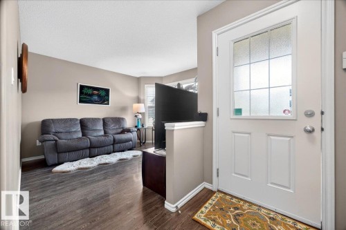 Entryway featuring a white paneled door with frosted grid-patterned glass, dark wood-finish flooring, and neutral wall tones - 18080 89 Street, Edmonton, AB - Indoor Photo Showing Living Room