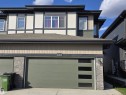 Modern facade featuring a segmented garage door with frosted glass panels, brick accents, and a tiered roofline - 6404 27 Avenue, Edmonton, AB  - Outdoor With Exterior 