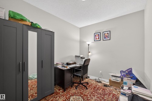 Smooth wall finishes, textured ceiling, and a patterned area rug define this interior space - 22638 99A Avenue, Edmonton, AB - Indoor Photo Showing Office
