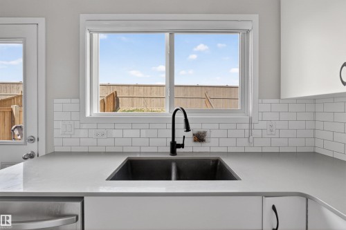 Kitchen featuring a modern matte black gooseneck faucet, a double basin sink, and light gray countertops - 22638 99A Avenue, Edmonton, AB - Indoor Photo Showing Kitchen With Double Sink