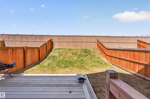 Spacious backyard featuring a wooden deck, sloped lawn, and perimeter wood fencing - 22638 99A Avenue, Edmonton, AB - Outdoor