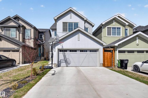 Modern two-story residence featuring a light gray exterior, an attached garage with a concrete driveway, and gabled rooflines - 22638 99A Avenue, Edmonton, AB - Outdoor With Facade