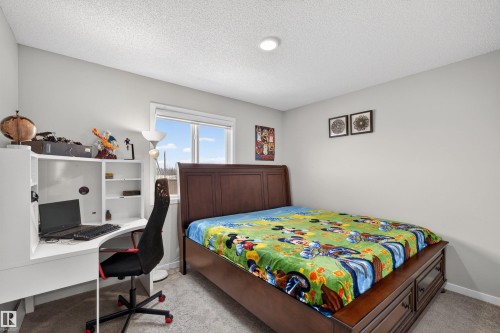 Room featuring light gray walls, carpet flooring, a window with white trim, a built-in ceiling light, and a white desk with shelving - 22638 99A Avenue, Edmonton, AB - Indoor Photo Showing Bedroom