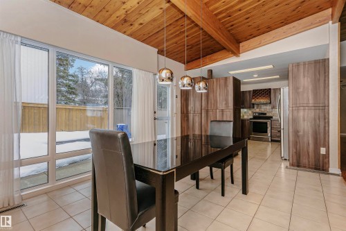 This area features a wood-paneled, vaulted ceiling, large windows, and tiled flooring - 24 Sable Crescent, St. Albert, AB - Indoor