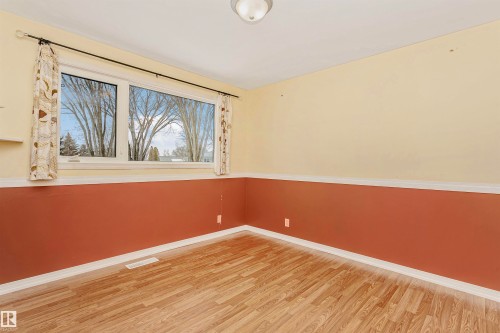 This room features wood-style flooring and a window with a view of trees - 24 Sable Crescent, St. Albert, AB - Indoor Photo Showing Other Room
