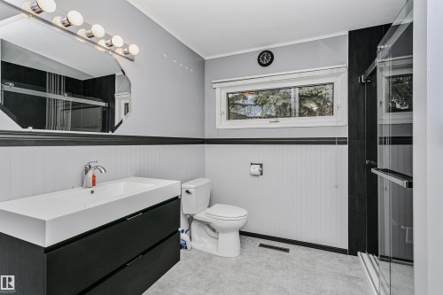 This bathroom features a contemporary floating vanity with a vessel sink, a toilet, a window, and a glass-enclosed shower - 24 Sable Crescent, St. Albert, AB - Indoor Photo Showing Bathroom