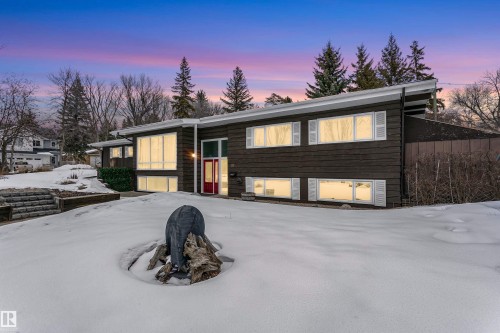 The property features a dark-toned exterior with white window shutters and a striking red entrance door - 24 Sable Crescent, St. Albert, AB - Outdoor