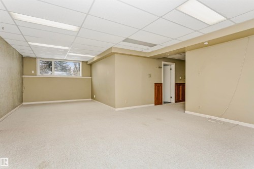 Spacious open room with carpeting, drop ceiling with recessed lighting, and a window providing natural light - 24 Sable Crescent, St. Albert, AB - Indoor Photo Showing Basement