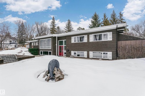 This property features a contemporary architectural style with dark siding, white window trim, and a red front door - 24 Sable Crescent, St. Albert, AB - Outdoor
