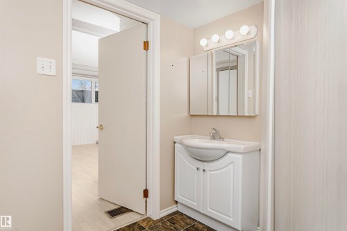 Bathroom vanity with a white countertop and base cabinet, complemented by a mirrored medicine cabinet and a four-bulb light fixture - 24 Sable Crescent, St. Albert, AB - Indoor Photo Showing Bathroom