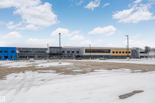 The property features a large building with a modern facade, including sections of blue, grey, and yellow panels - 24 Sable Crescent, St. Albert, AB - Outdoor With View