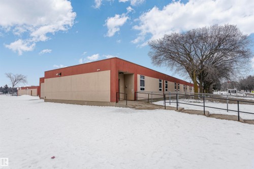 The property features a building with a two-tone exterior, presenting a blend of a terracotta-colored upper section and a lighter beige lower section - 24 Sable Crescent, St. Albert, AB - Outdoor